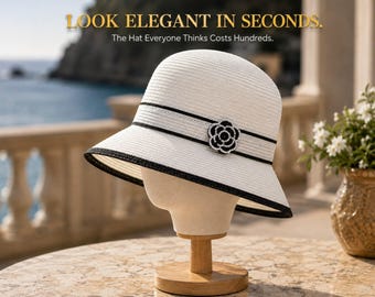 May include: A white straw bucket hat with a black ribbon band and a black and white flower-shaped embellishment. The text LOOK ELEGANT IN SECONDS. The Hat Everyone Thinks Costs Hundreds. is visible at the top of the image.