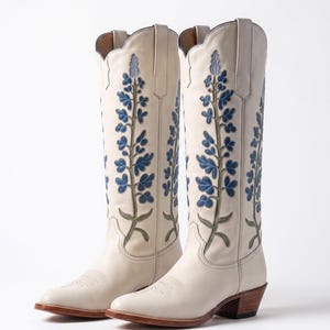 Botas de couro branco estilo cowboy, com bordado de flores azuis, cano alto estilo cowgirl ocidental.