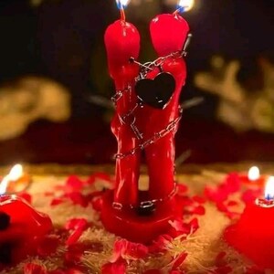 Pu&ograve; includere: Due candele rosse, modellate per assomigliare a due figure che si abbracciano, con fiamme in cima. Un ciondolo a forma di cuore nero &egrave; appeso tra loro e sono avvolte in una catena d'argento. Le candele sono circondate da petali di rosa.