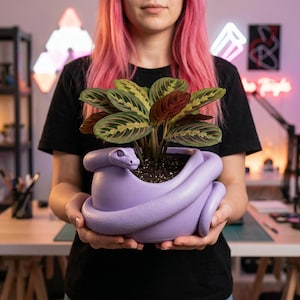 Könnte beinhalten: Ein Set aus drei Keramikbechern mit gesprenkelter, matter Oberfläche. Jeder Becher hat eine andere Farbe: Hellblau, Creme und Grau. Die Becher haben ein schlichtes, modernes Design und einen bequemen Griff.