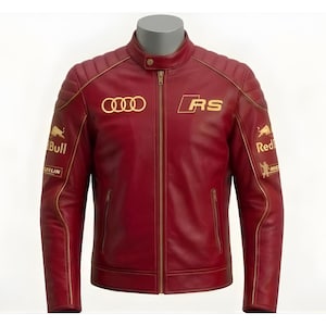 May include: A burgundy leather jacket with gold accents and logos. The jacket features a stand-up collar, a front zipper, and multiple embroidered logos, including "AUDI", "RS", and "Red Bull". The jacket has a quilted design on the shoulders.