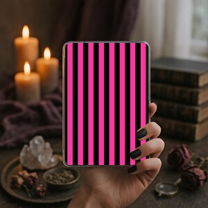 May include: A rectangular tablet case featuring a vertical striped pattern in alternating hot pink and black colors. The case has a clear, thin border around the edges, showcasing a bold, high-contrast design with uniform, straight lines.