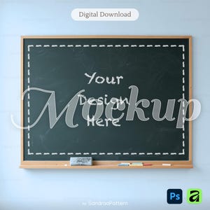 May include: A rectangular dark green chalkboard with a wooden frame, featuring a white dashed border drawn in chalk. The text Your Design Here is written in the center. A chalk eraser and several small pieces of colored chalk sit on the ledge.