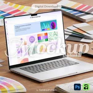 Op de afbeelding: Een zilveren Macbook-laptop met een ontwerpinterface, omringd door kleurstalen en ontwerptools. Het scherm toont de tekst "Merkmateriaal" en "Digital Download". De afbeelding staat op een houten oppervlak.