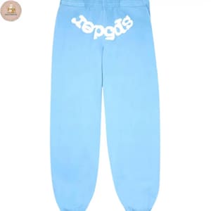 Puede incluir: Pantalones de ch&aacute;ndal azul claro con la palabra "spider" en blanco, arqueada en la parte trasera de la cintura. Los pantalones son de color liso, con un corte holgado y cintura con cord&oacute;n. La tela parece suave y c&oacute;moda.