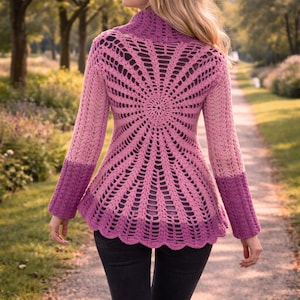May include: A handmade, open-weave crochet jacket in shades of pink and purple. The jacket features a high collar and long sleeves with a scalloped hem. The back has a sunburst design. The person is wearing black pants.