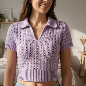 Puede incluir: Un polo de crochet lila claro de manga corta. La camisa presenta un cuello y un diseño de cuello en V. El patrón de crochet incluye detalles calados en la parte delantera y las mangas, con dobladillo y puños acanalados.