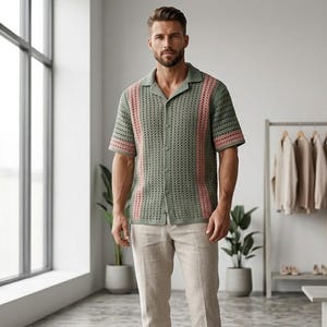 Puede incluir: Una camisa verde con botones de tejido abierto con rayas verticales rosas y mangas cortas. La camisa se combina con pantalones beige claro. La camisa tiene cuello y est&aacute; abotonada. El atuendo es casual y elegante.