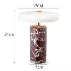 May include: A decorative table lamp with a white lampshade and a cylindrical base. The base is a dark red color with white marbling. The lamp is 21 cm tall, the lampshade is 17 cm wide, and the base is 7 cm wide.