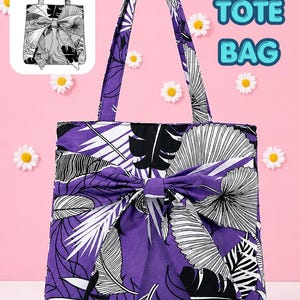 Op de afbeelding: Een paarse tote bag met een grote stoffen strik aan de voorzijde en een zwart-wit tropisch bladerenpatroon. De tas heeft twee schouderbanden en de tekst BOW TOTE BAG staat in de rechterbovenhoek van de afbeelding.