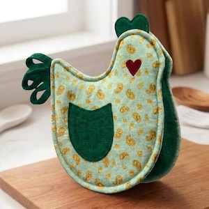 May include: A chicken-shaped oven mitt featuring a light green fabric with a yellow paisley pattern. It includes a dark green fabric pocket, a dark green comb and tail, and a small red heart appliqué on the side of the chicken's head.