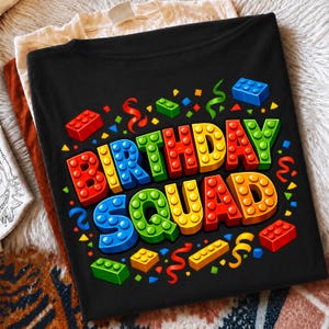 May include: A black t-shirt featuring the text "BIRTHDAY SQUAD" in a colorful, three-dimensional block-style font that resembles plastic building bricks. The design is surrounded by scattered confetti and various red, blue, green, and yellow brick pieces.
