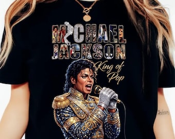 Peut inclure: T-shirt noir avec un graphisme de Michael Jackson, et le texte "MICHAEL JACKSON King of Pop". Le design comprend un portrait de Jackson et des images dans les lettres de son nom.