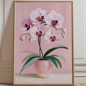Peut inclure: Une impression d'art encadrée représentant une peinture d'orchidée en pot avec des pétales rose clair et des centres magenta foncé. La plante possède de longues feuilles vert foncé et est placée dans un pot en céramique rose clair sur fond rose.