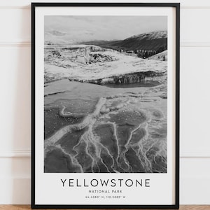 Peut inclure: Tirage encadré en noir et blanc du parc national de Yellowstone. L'image présente un paysage avec des caractéristiques thermales et des montagnes. Le texte "YELLOWSTONE NATIONAL PARK" est imprimé en bas, avec les coordonnées 44.4280° N, 110.5885° W.