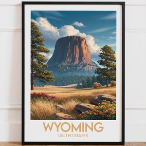Peut inclure: Une affiche encadrée représentant le Devils Tower du Wyoming, aux États-Unis, sous un ciel bleu nuageux. L'image montre un paysage avec des arbres, des champs et le texte "WYOMING UNITED STATES" en bas, célébrant la beauté naturelle de la région.