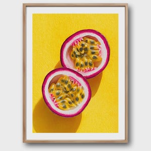 Könnte beinhalten: Gerahmter Druck mit zwei Hälften einer Passionsfrucht, die die leuchtend violette Schale und das gelbe Fruchtfleisch mit Samen zeigt. Die Frucht liegt auf einem leuchtend gelben Hintergrund, was einen auffälligen Kontrast erzeugt. Das Kunstwerk wird in einem Holzrahmen präsentiert.