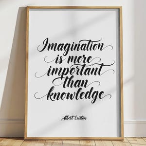Pode incluir: Impressão emoldurada com a citação "A imaginação é mais importante que o conhecimento" em escrita preta sobre fundo branco. A moldura de madeira clara é adequada para decoração de interiores.