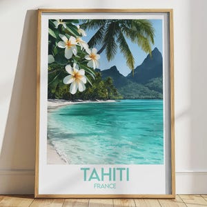 Könnte beinhalten: Ein gerahmter Druck mit einer tropischen Strandszene. Das Kunstwerk zeigt einen türkisfarbenen Ozean, weißen Sand und grüne Palmen. Weiße Blüten blühen im Vordergrund. Der Text "TAHITI FRANCE" befindet sich unten.