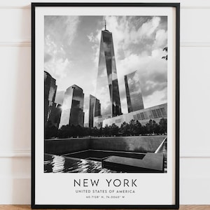 Peut inclure: Tirage encadré en noir et blanc représentant l'horizon de New York. L'image met en valeur le One World Trade Center et d'autres gratte-ciels, avec le nom de la ville et ses coordonnées en bas. L'impression est présentée dans un cadre noir.