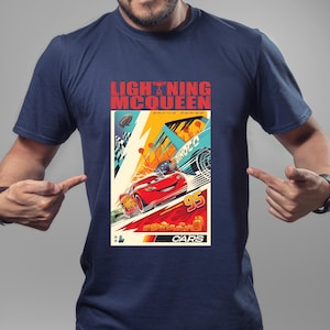 May include: Navy blue t-shirt featuring a graphic of Lightning McQueen from the Cars movie. The design includes the text "LIGHTNING McQUEEN" and "95" with racing elements in a vibrant color palette.