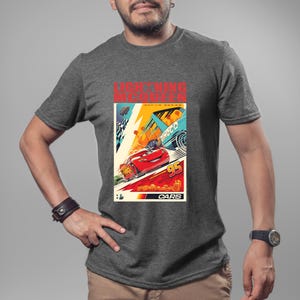 May include: A gray t-shirt featuring a colorful graphic of Lightning McQueen from the movie Cars. The design includes the text "LIGHTNING MCQUEEN" and "CARS", along with the number "95". The graphic has a vintage poster style.