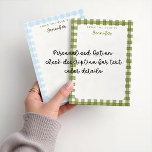 May include: Two rectangular note pads with gingham borders in light blue and olive green. Each features the text FROM THE DESK OF Jennifer and the central text Personalized Option check description for text color details.