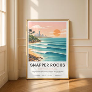 May include: A framed art print featuring a coastal scene with ocean waves, a sandy beach, and a cityscape in the background. The artwork has a warm color palette with a golden frame. The text "SNAPPER ROCKS GOLD COAST, AUSTRALIA" is displayed at the bottom.