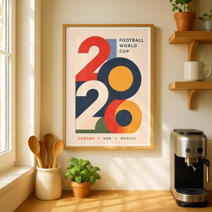Pu&ograve; includere: Un poster incorniciato con un design retr&ograve; per la Coppa del Mondo di Calcio 2026, con il numero 2026 in forme rosse, bianche, blu e arancioni. Il testo "FOOTBALL WORLD CUP" e i paesi "CANADA &bull; USA &bull; MEXICO" sono visibili.
