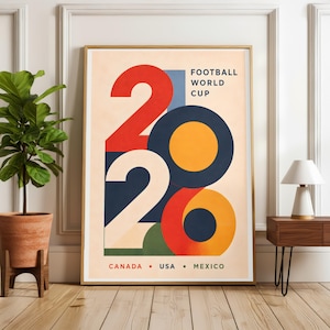 Pu&ograve; includere: Poster incorniciato con un design geometrico per la Coppa del Mondo di Calcio 2026. Il poster presenta il numero 2026 in rosso, bianco e blu navy, con un cerchio arancione. Il testo "FOOTBALL WORLD CUP" &egrave; in alto e "CANADA &bull; USA &bull; MEXICO" in basso.