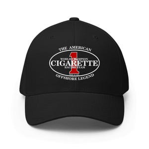 May include: Black baseball cap with a curved brim. The cap features a white oval logo with the words "CIGARETTE RACING TEAM" and "OFFSHORE LEGEND" in white text. The logo also includes the number "1" in red.