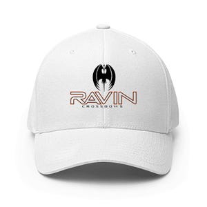 May include: White baseball cap with a curved brim. The cap features a black and red logo with the word "RAVIN" and the text "CROSSBOWS". The logo includes a stylized bat-like emblem.