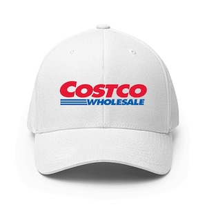 May include: White baseball cap featuring the Costco Wholesale logo in red and blue. The logo is displayed prominently on the front. The cap has a curved peak and a structured design.