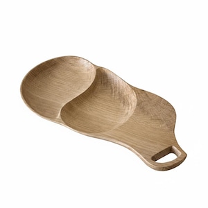 Peut inclure: Un plateau de service en bois brun clair avec deux compartiments arrondis et une poignée. Le plateau est en bois naturel et a une finition lisse. La poignée a une ouverture rectangulaire.