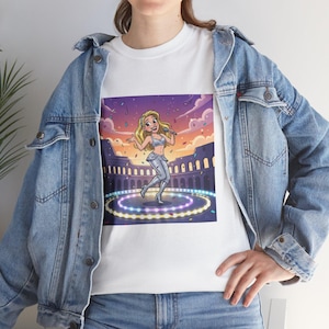 May include: White t-shirt with a cartoon image of a blonde singer in a silver outfit performing on a stage, with a Roman Colosseum backdrop. The stage is lit with colourful lights.