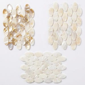 Può includere: Tre composizioni di piastrelle a mosaico ovali e iridescenti. Un gruppo presenta toni oro e crema, un altro è color crema e il terzo è color crema pieno. Le piastrelle sono disposte a griglia.