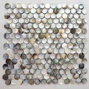 Può includere: Un set di tre ciotole in ceramica ad incastro di dimensioni graduate. Le ciotole presentano una finitura opaca e maculata nei toni del crema, marrone chiaro e marrone scuro. La ciotola più grande ha un diametro di circa 18 cm.