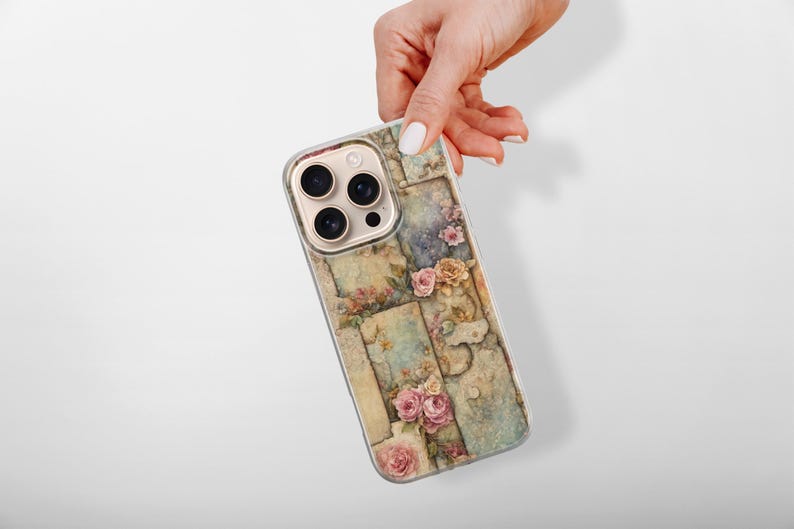 May include: A phone case with a floral design, showing a collage of vintage-style panels with roses and other flowers in pink, yellow, and cream. The case has a gold camera module and a clear border.