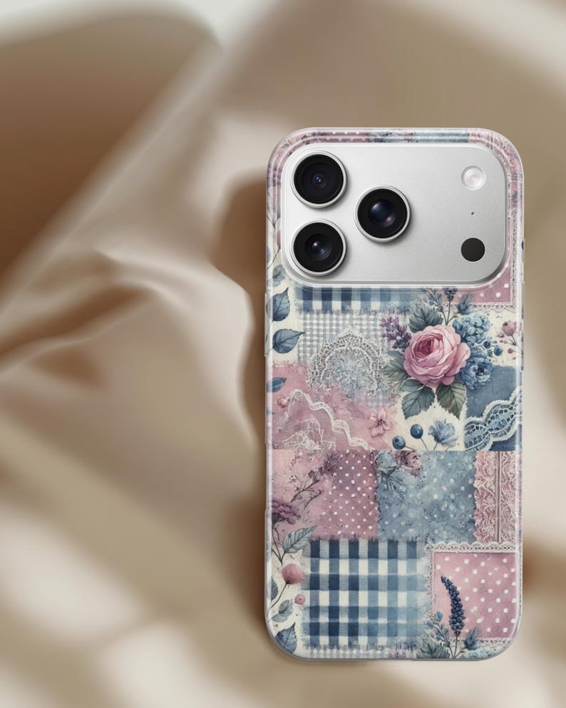 May include: A phone case with a patchwork design featuring floral and lace patterns in pink, blue, and white. The case has a clear border and a camera cutout.