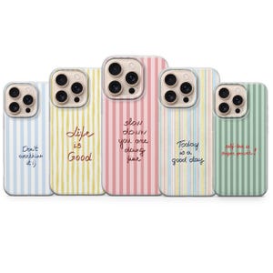 Pode incluir: Cinco capas de telefone com padrões de riscas verticais em cores pastel. Cada capa tem uma citação inspiradora diferente em estilo manuscrito: "Don't overthink it :)", "Life is Good", "slow down you are doing fine", "Today is a good day", e "self-love is super power!"