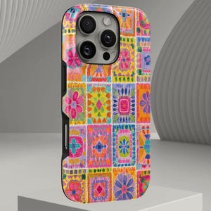 Puede incluir: Una funda para smartphone con un diseño de patchwork vibrante y multicolor. El patrón consta de varios bloques rectangulares rellenos de intrincados motivos florales y geométricos en tonos rosa, naranja, amarillo, azul y morado.