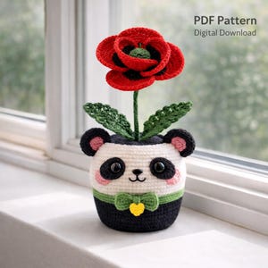 Puede incluir: Una maceta de panda de ganchillo con una flor de amapola roja. La maceta de panda es blanca con detalles en negro, mejillas rosas y una pajarita verde. La amapola tiene pétalos rojos con detalles en negro. El texto "PDF Pattern Digital Download" está en la esquina superior derecha.