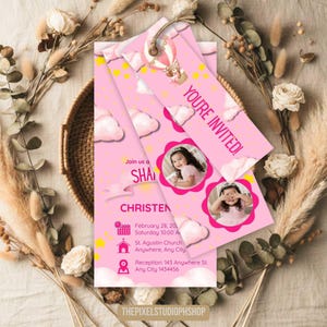 May include: Pink invitation cards with a hot air balloon, clouds, and a teddy bear design. The cards include the text "YOU'RE INVITED!" and details for a christening, including the date, time, and location. The cards also feature two photos of a young girl.