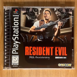 May include: A PlayStation game case for Resident Evil: 30th Anniversary Director's Cut. The cover shows a man holding a rifle, with zombie figures. The game case is in a clear plastic case.