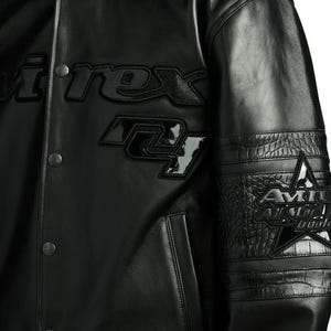 Puede incluir: Chaqueta de cuero negra con el texto "i.rex" y "24" en la parte delantera. La chaqueta presenta una estrella y texto en la manga. La chaqueta tiene una botonadura frontal y un patr&oacute;n texturizado en las mangas.