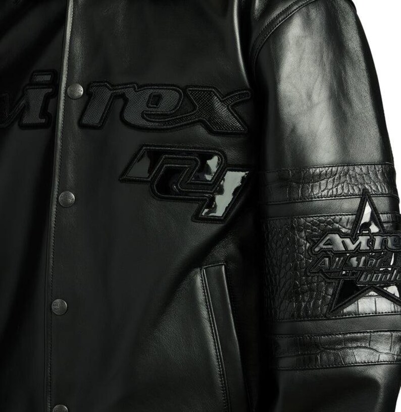 Puede incluir: Chaqueta de cuero negra con el texto "i.rex" y "24" en la parte delantera. La chaqueta presenta una estrella y texto en la manga. La chaqueta tiene una botonadura frontal y un patr&oacute;n texturizado en las mangas.