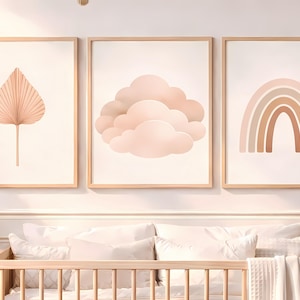 Puede incluir: Tres impresiones artísticas enmarcadas con una paleta de colores neutros. Las impresiones presentan una hoja color melocotón, nubes esponjosas y un arcoíris. Los marcos son de madera clara.