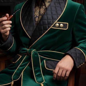 Könnte beinhalten: Smaragdgrüner Samtrobe mit schwarzen, gesteppten Revers und Manschetten, mit goldener Kordel verziert. Mit passendem Gürtel mit Quasten und goldenen Knöpfen. Getragen über einem Hemd mit Paisley-Muster und einer dunklen Krawatte.