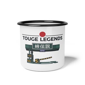 May include: White enamel mug with a black rim featuring the text "TOUGE LEGENDS" and Japanese text. A red circle is above the text. Below the text is a green and yellow graphic of a toll booth.