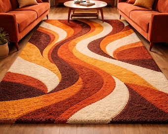 May include: A rectangular area rug featuring a shaggy texture and a repeating pattern of wide, undulating waves in shades of burnt orange, deep brown, golden yellow, and cream. The rug covers a wooden floor between two orange sofas.